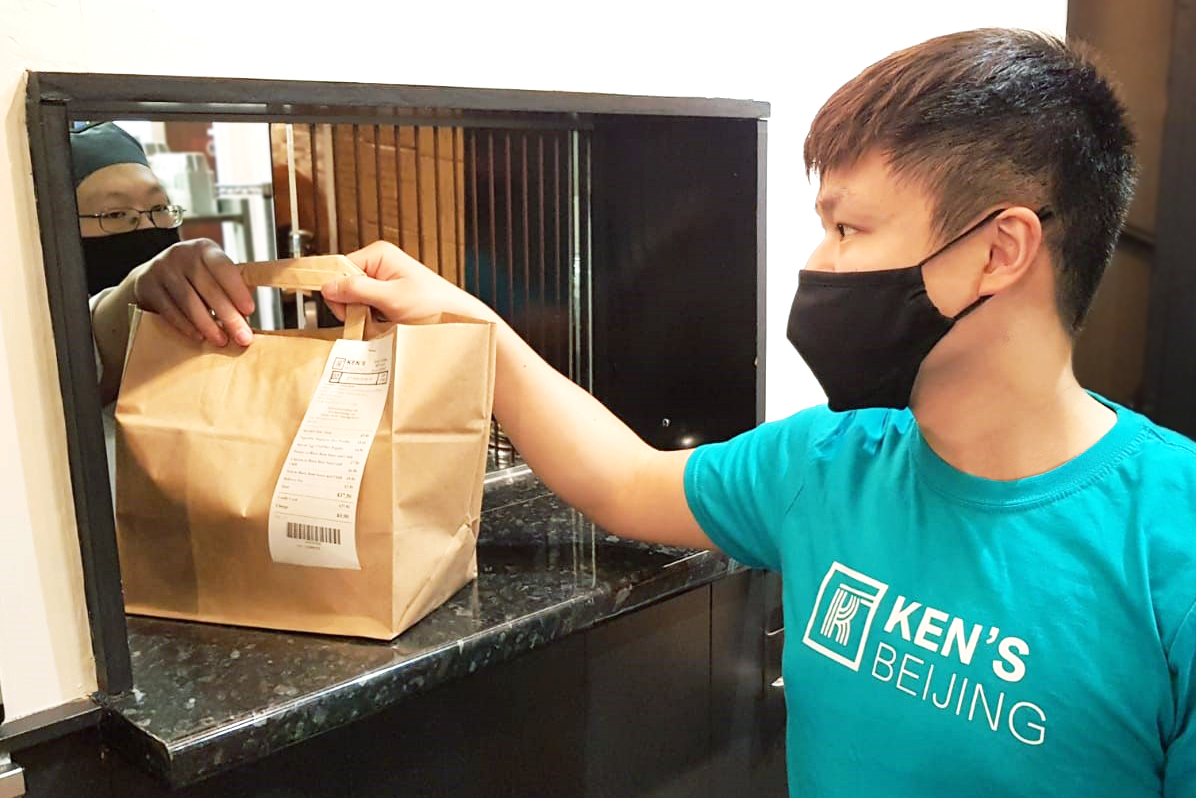 Chinese small businesses lockdown. Jonny Leung picks up food that is ready for delivery at Ken's Beijing.