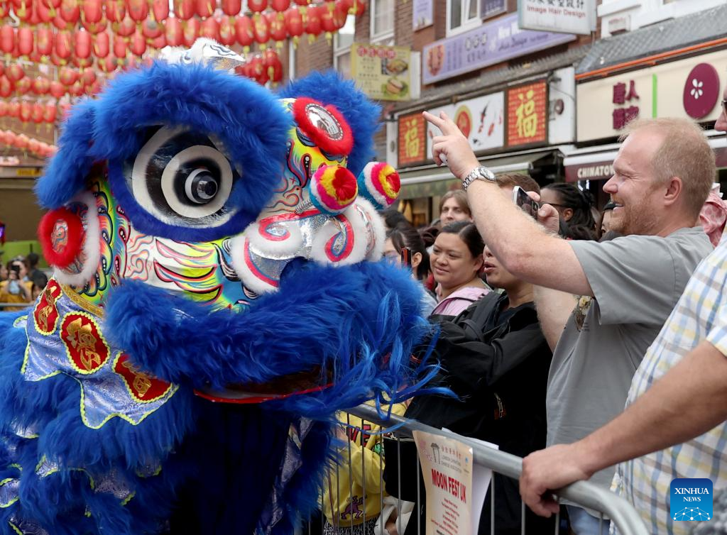 Locals watch a lion dance performance at a show for the celebration of the Chinese Mid-Autumn Festival in London, Britain, Sept. 24, 2023. (Xinhua/Li Ying)