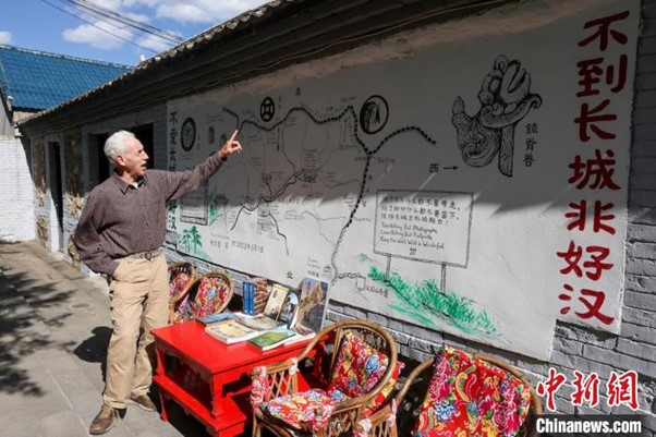 William Lindesay pointing at a map of the Great Wall.