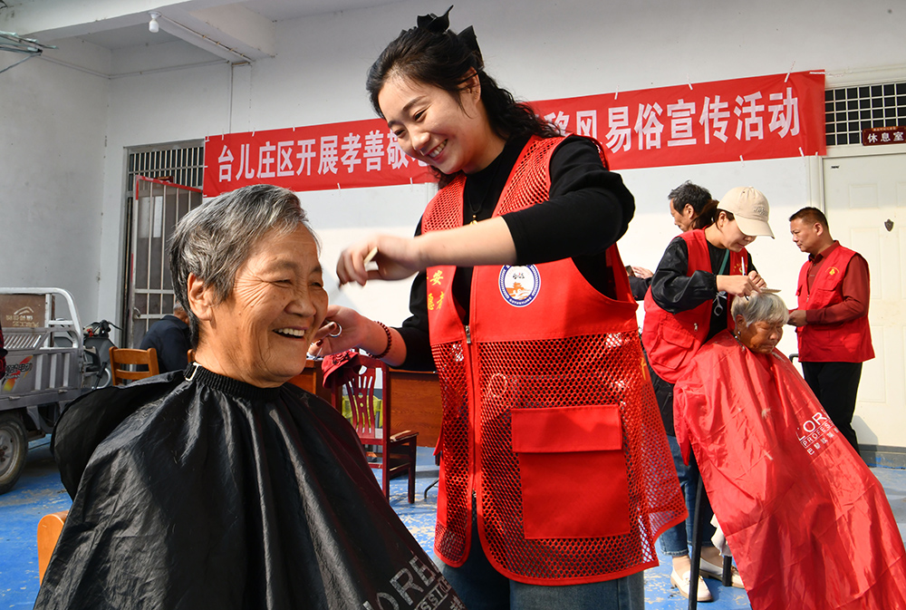 A volunteer gives free haircut to an elderly woman in Shandong.