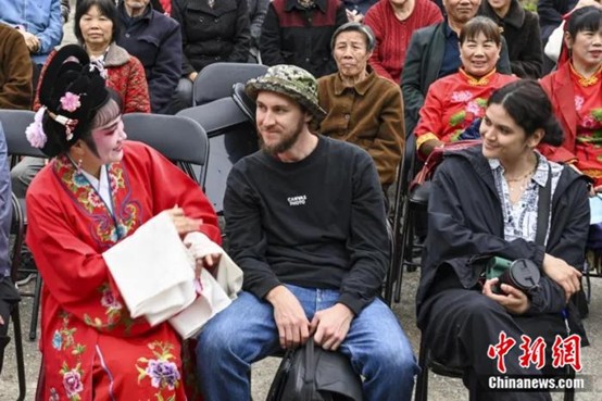 Linxiang Huagu Opera performers interacting with foreign photographers. Photo by Yang Shihao